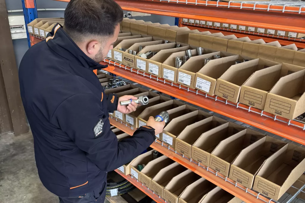 Technicien Full Service Industrie devant le rayonnage des raccords hydrauliques du comptoir d’Ablon-sur-Seine