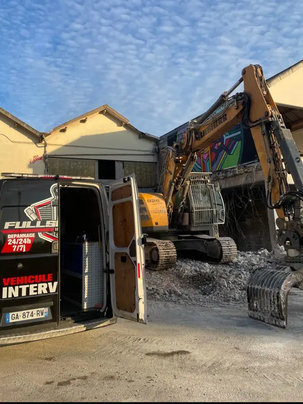 Camion-atelier ouvert au pied d’une pelle, sur un chantier