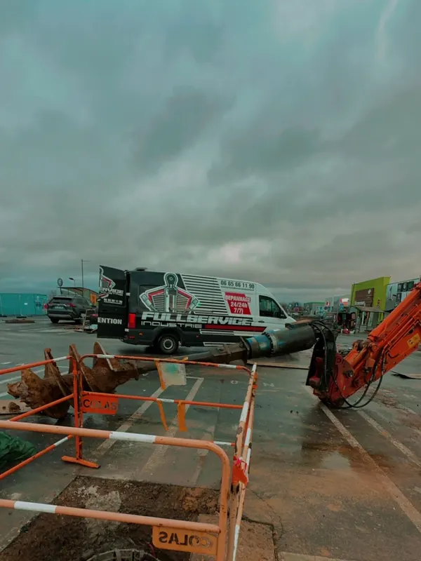 Camion-atelier sur un chantier de voirie, derrière les barrières