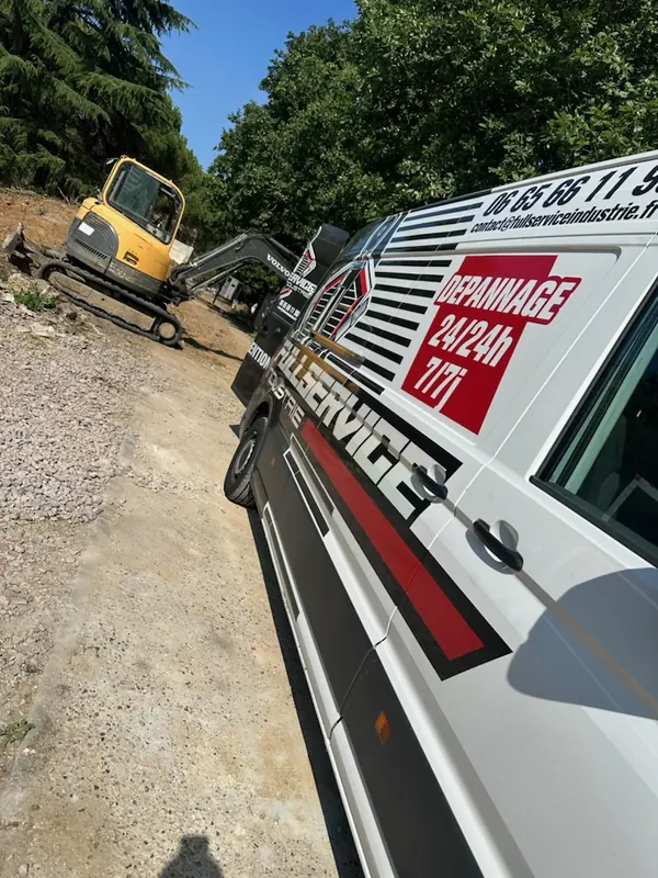 Camion-atelier à côté d’une mini-pelle sur un chantier de terrassement