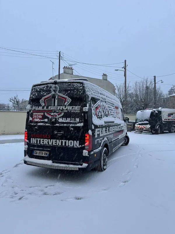 Camion-atelier noir sous la neige