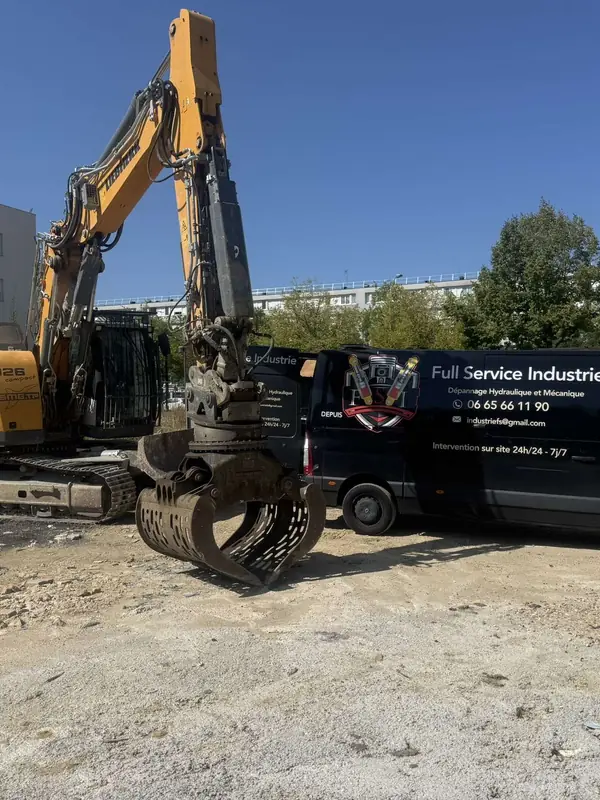 Camion-atelier au pied d’une pelle à grappin