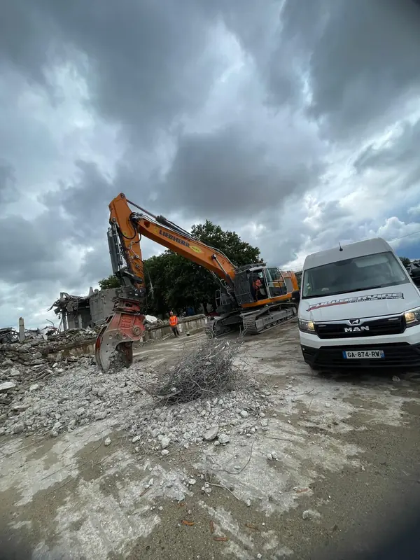 Camion-atelier à côté d’une pelle sur un chantier de démolition