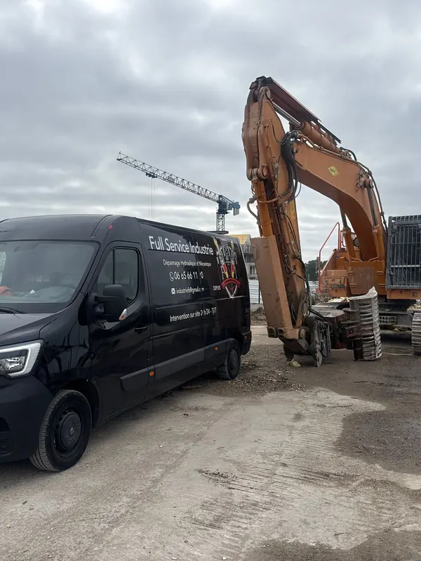 Camion-atelier devant une pelle, sur un chantier