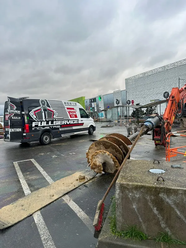 Camion-atelier à côté d’une pelle équipée d’une tarière