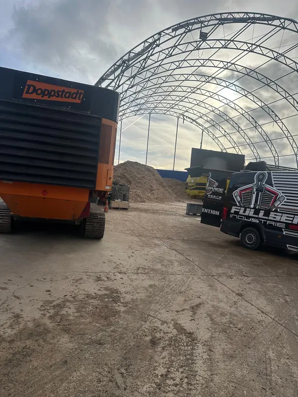 Camion-atelier sur une plateforme, à côté d’un broyeur