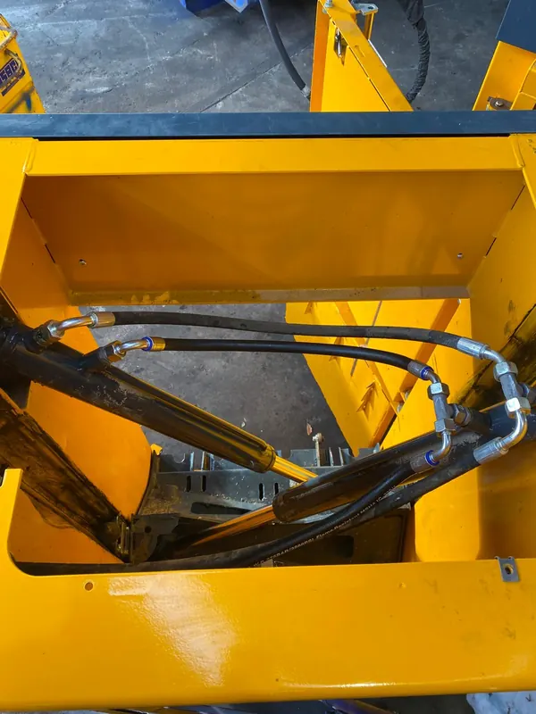 Flexibles hydrauliques neufs dans le bâti jaune d’une machine