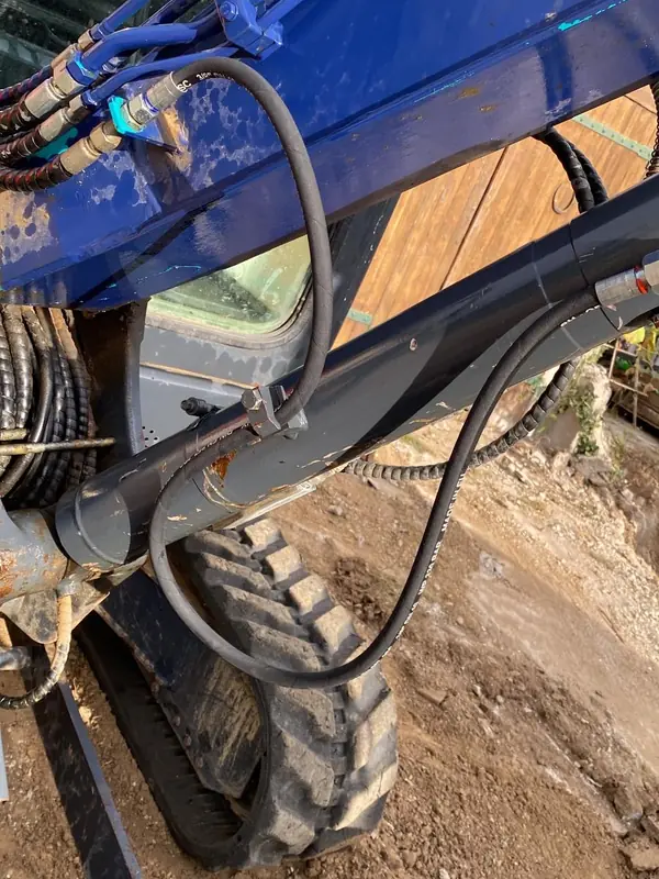 Flexibles hydrauliques sur le bras d’une pelle