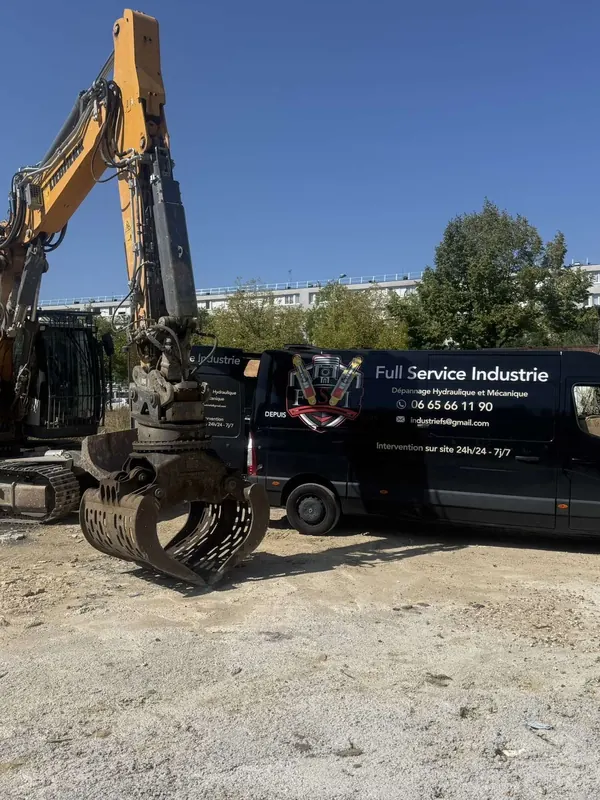 Pelle à grappin et camion-atelier sur un terrain en chantier